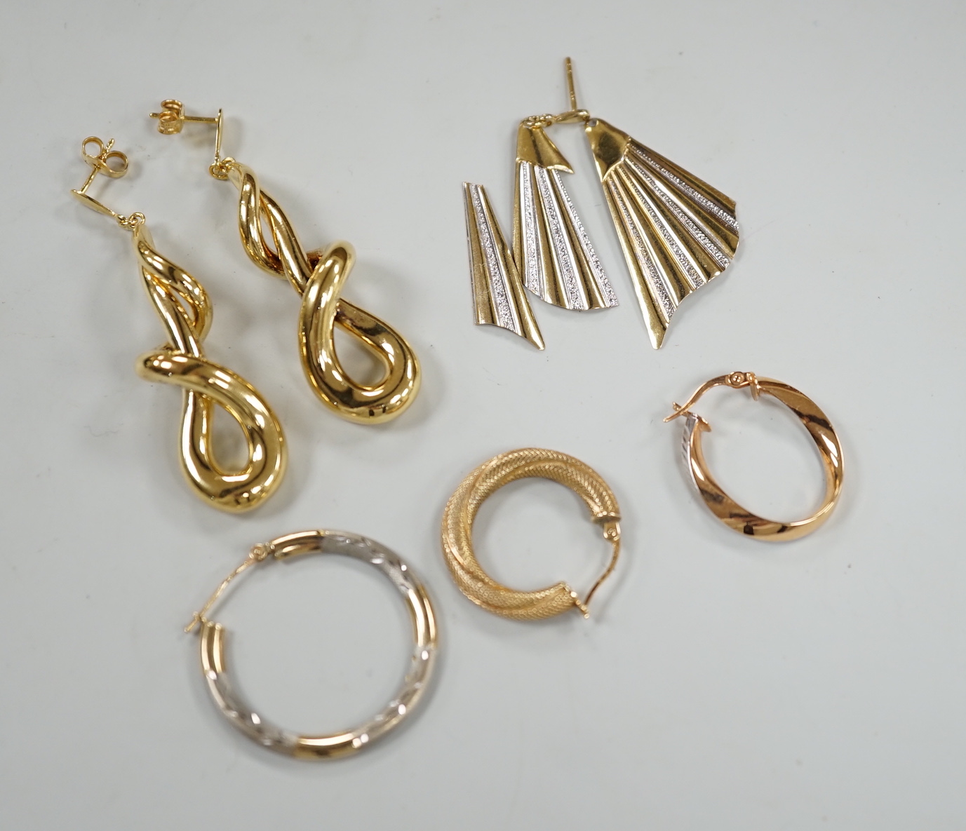 A modern pair of 9ct gold scrolling drop earrings, 47mm, three odd 9ct gold earrings and three 9ct earring fragments, 13.4 grams.